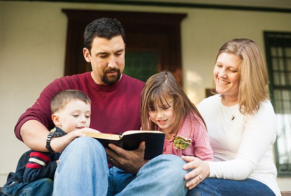 Parents read the bible with their children.