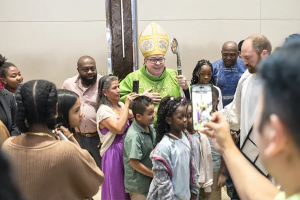 Bishop Michael Olson takes a photo with parishioners on World Mission Sunday.