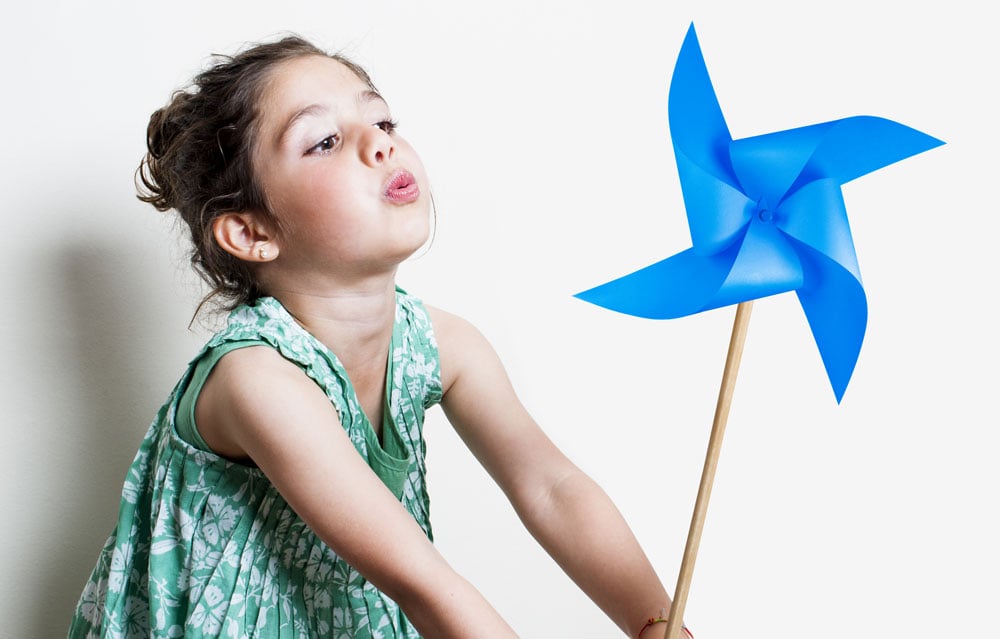 A child plays with a blue pinwheel.