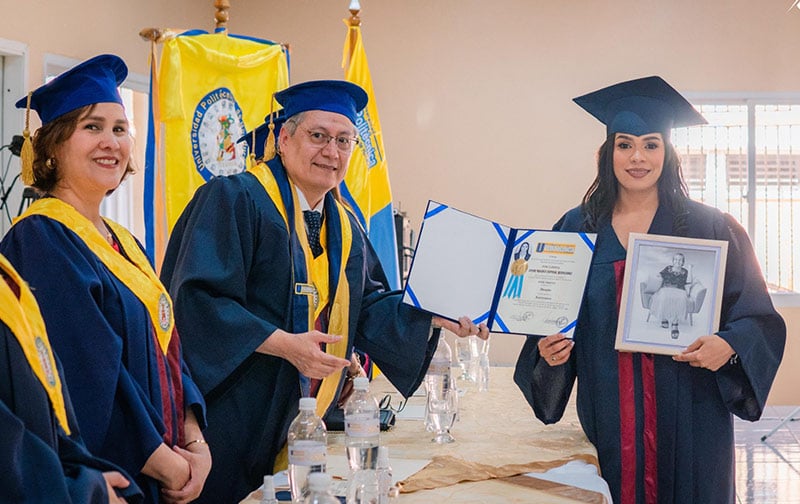 Leydi Espinal holds up her law school diploma with a picture of her grandmother.