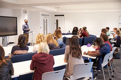 Students study in a classroom with male lecturer.