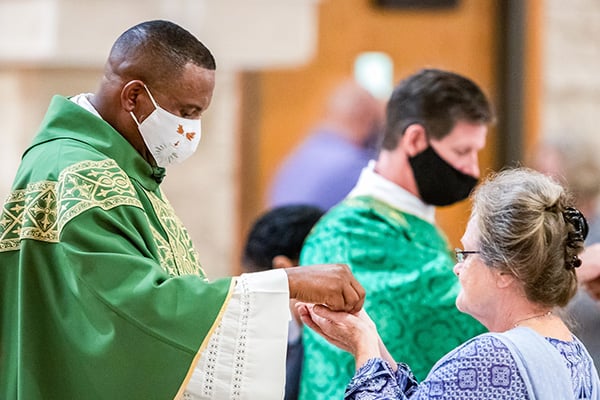 A Missionary Priest distributes Communion at St. Francis of Assisi in Grapevine, Texas.